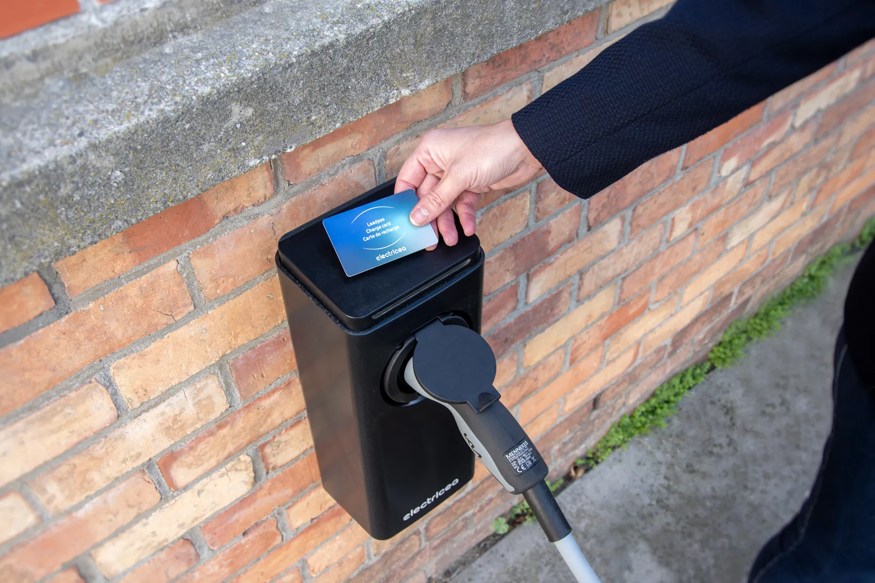 Een Electricea-laadpas wordt voor een laadstation gehouden