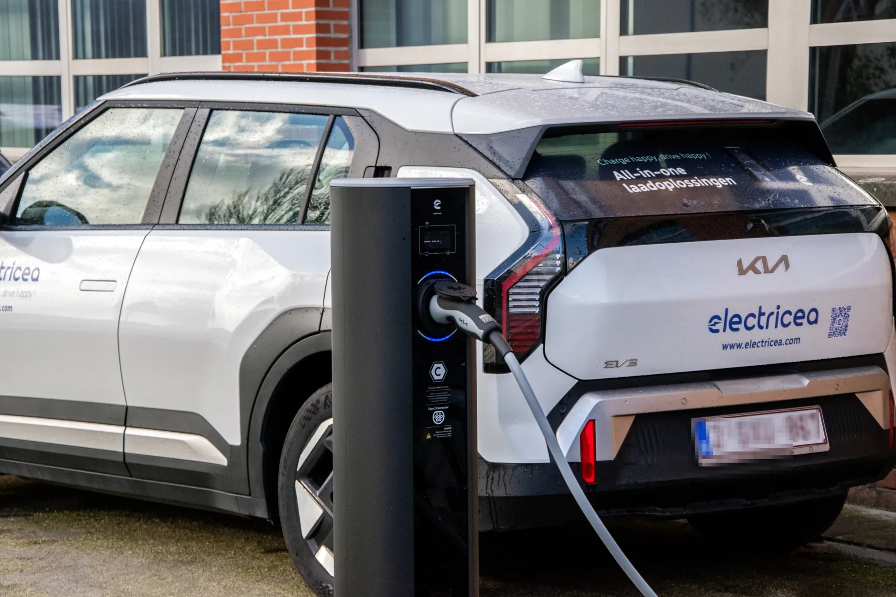 Een bedrijfswagen laadt aan een laadpunt op de bedrijfsparking
